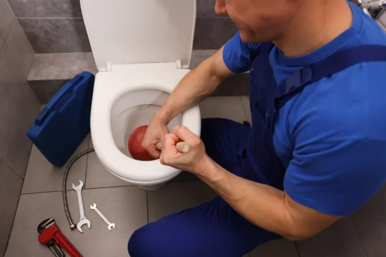 Plumber unblocking toilet